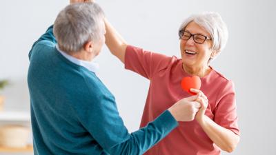 Mann und Frau tanzen mit einem Herz in der Hand