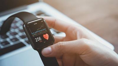 Frau hält eine Smartwatch in der Hand