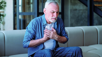 Patient fasst sich mit Brustschmerzen ans Herz