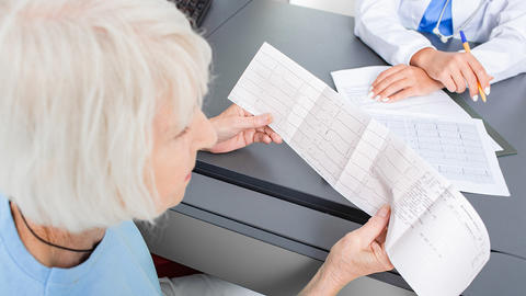 Frau betrachtet geschriebenes EKG