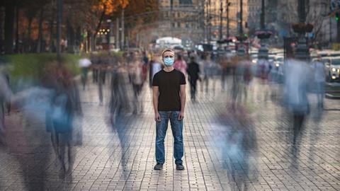 Einsam mit Maske in der Menschenmenge Einsam mit Maske in der Menschenmenge