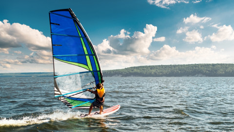 Erwachsener surft über das Meer